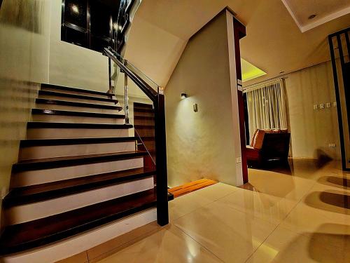 a staircase in a living room with a stair case at Staycation At Sandari Batulao Overlooking Spot in Tagaytay