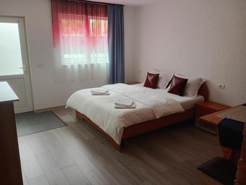 a bedroom with a large bed with a window at Casa Tamara in Turda