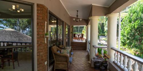 a porch of a home with glass doors and chairs at Villa Kupa in Zomba