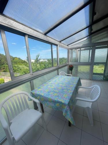 une véranda avec une table et des chaises dans l'établissement Appartement calme - Proche Toulouse, à Ramonville-Saint-Agne