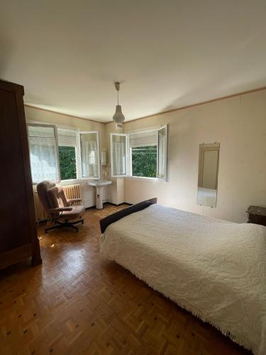 une chambre avec un lit, une chaise et des fenêtres dans l'établissement Appartement calme - Proche Toulouse, à Ramonville-Saint-Agne