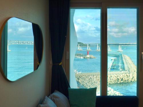 a room with a window with a view of the ocean at Ocean Front Apartment in Busan