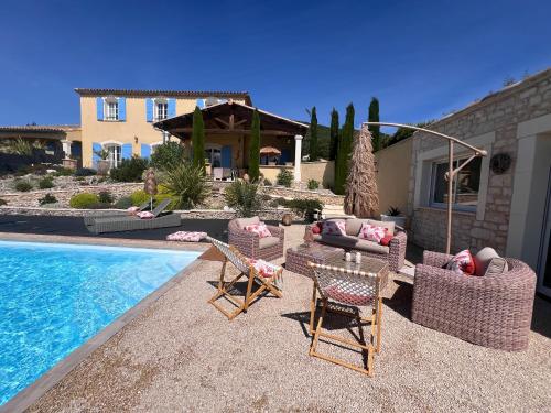 une arrière-cour avec une piscine, des chaises et une maison dans l'établissement La Bastide de Grosille, à Savasse