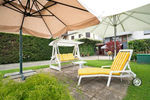 two chairs and a swing and an umbrella at Miniappartamento Il Gelsomino in Spinea