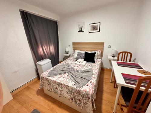 een kleine slaapkamer met een bed en een bureau bij Habitación interior en Madrid in Madrid