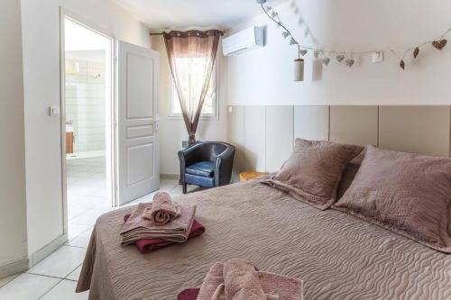 une chambre avec un lit avec un peignoir dessus dans l'établissement Villa Le Petit Nid by Villa Plus, à Villedaigne