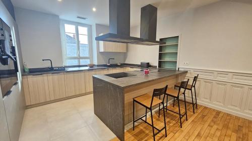 une cuisine avec un comptoir avec des chaises et un évier dans l'établissement Vercingetorix 6 #Confort, à Aubière