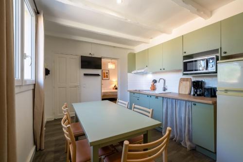 une cuisine avec une table et des chaises dans une pièce dans l'établissement Stone house T3 in a tourist residence, à La Roque-sur-Pernes
