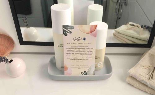 a bathroom counter with a bottle of soap and a mirror at 'Das kleine Feine' - Ruhige, helle Ferienwohnung mit Parkplatz und Balkon in Pforzheim