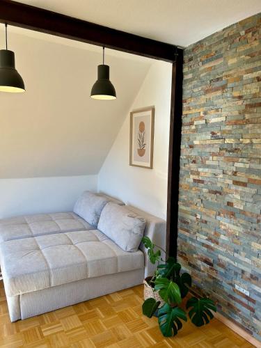 a bedroom with a bed and a brick wall at Appartement zur Mühle in Altenberge