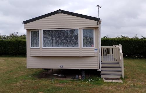 a tiny house with a porch and a window at Happy Havan in Great Yarmouth