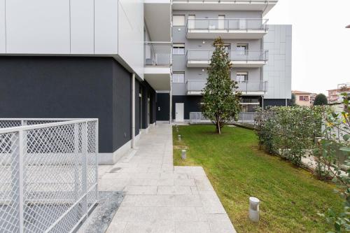 ein Apartmenthaus mit einem Zaun und einem Hof in der Unterkunft Cenisio 12 in Bergamo