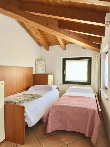 明乔河畔的瓦雷奇奥La casa di Nina - Appartamenti Deluxe的有窗户的房间里有两张床