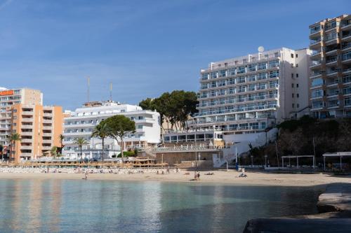 a beach with buildings and people on the beach at Flamboyan Caribe Hotel & Spa in Magaluf