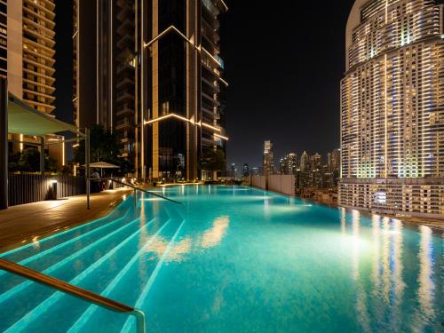a swimming pool on top of a building at night at The Dubai Mall Suite Luxury 1-Bed Near Burj Khalifa in Dubai