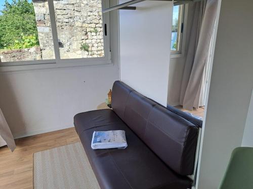 a living room with a couch with a book on it at Eco lodge, vue exceptionnelle! in Duclair