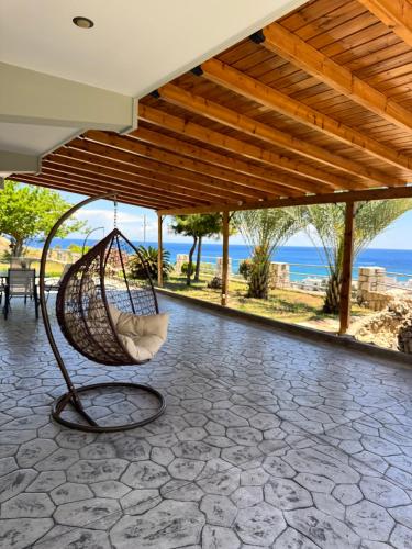 a swing on a porch with a view of the ocean at Villa Rose in Archangelos