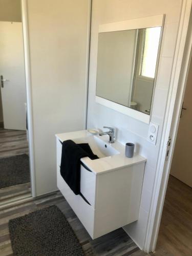 une salle de bain avec un lavabo blanc et un miroir dans l'établissement Ty Kilek - entre bourg et plage, à Saint-Gildas-de-Rhuys