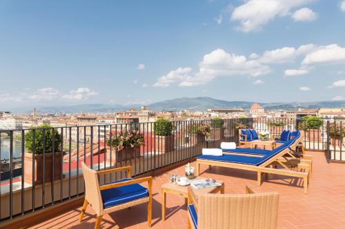 a balcony with chairs and tables and a view of a city at Hotel Lungarno - Lungarno Collection in Florence