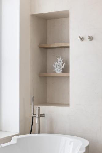 a bathroom with a white tub and a sink at Hotel Bommelje in Domburg