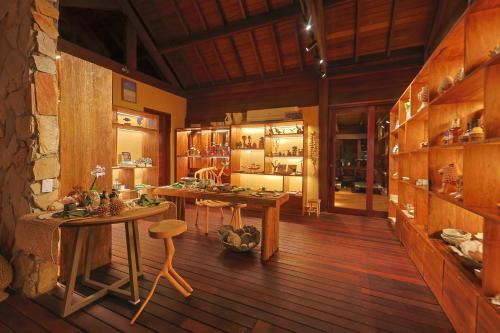 a room with wooden floors and tables in a building at Anttunina Pousada e SPA in Maragogi