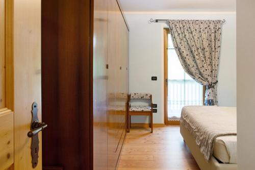 a bedroom with a bed and a glass door with a window at Villa Enrica in Transacqua