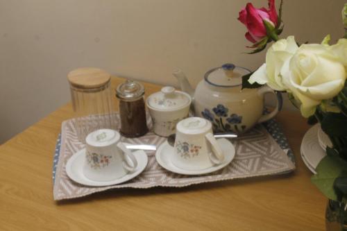 a table with three cups and plates and a vase at Umoya in Hilton