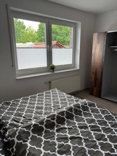 a bedroom with a black and white bed with a window at 3 Zimmer Ferienwohnung Nummer 1 in Hilter am Teutoburger Wald