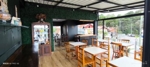 a restaurant with tables and chairs in a room at Vilarejo da Esperanza in Campos do Jordão