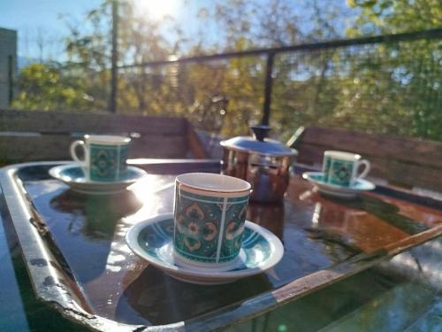 trois tasses à café et soucoupes sur une table en verre dans l'établissement Mi alma deptos, à Mendoza