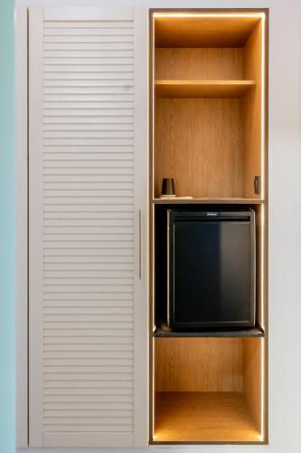 a small tv sitting inside of a book shelf at Messinian Bay in Kalamata