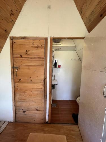 a bathroom with a wooden door in a attic at Nấp Đà Lạt in Da Lat
