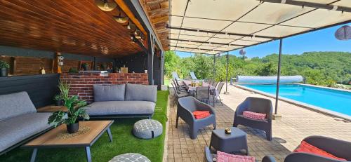 a patio with a couch and chairs and a pool at Le gîte du besson Cassagne in Cassagne