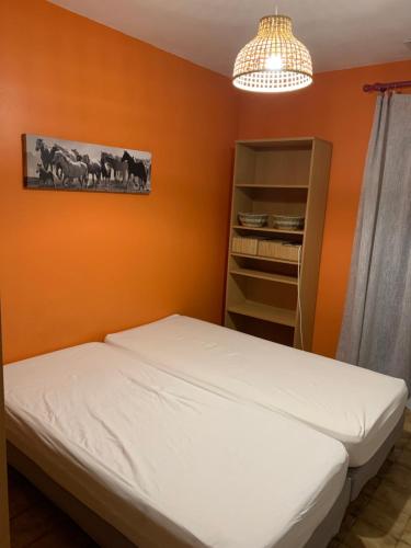- une chambre avec un lit et un mur orange dans l'établissement VILLA CATALANE, à Villemolaque