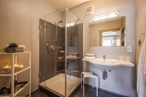 une salle de bain avec une douche en verre et un lavabo dans l'établissement Haus Alpin, à Ellmau