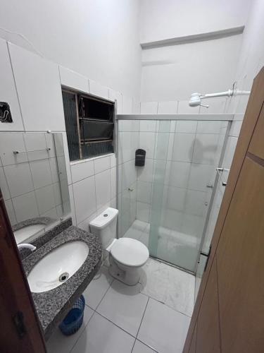 a bathroom with a toilet and a glass shower at Hotel Real in Bom Jesus da Lapa