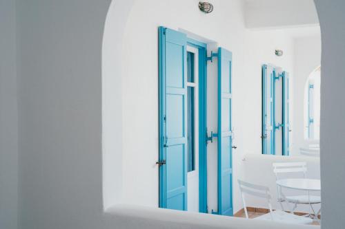 a room with a blue door and a table at Paros Inn Seafront in Logaras