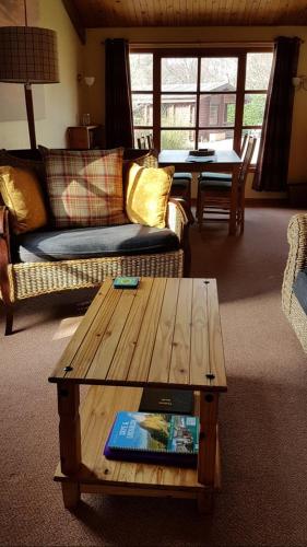 a living room with a couch and a coffee table at Eigg Lodge in Duirinish