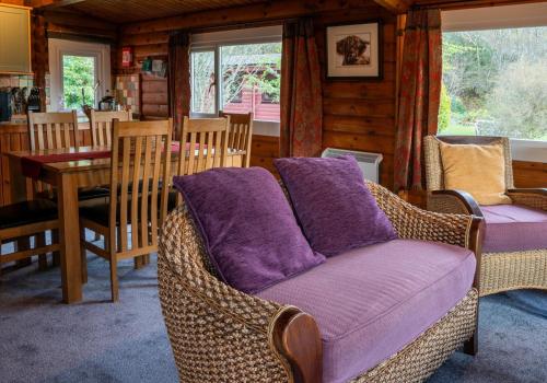 a living room with a couch with purple pillows at Skye Lodge in Duirinish