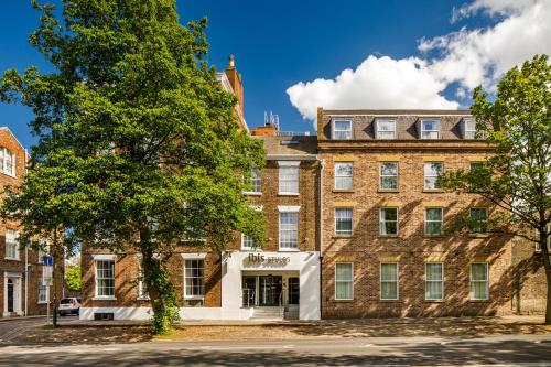 an old brick building with a tree in front of it at ibis Styles York Centre in York
