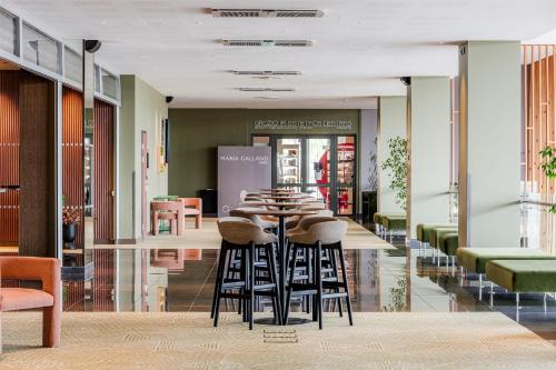 a restaurant with a long table and stools at Radisson Blu Hotel Lietuva in Vilnius