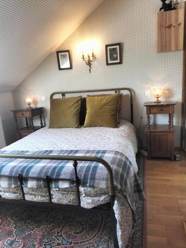 une chambre avec un lit et deux lampes au mur dans l'établissement Les Chanterelles La souris des champs, à Étival-Clairefontaine