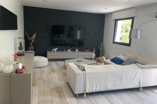 un salon avec un canapé blanc et une télévision dans l'établissement House 6p with private pool in Fréjus, à Fréjus