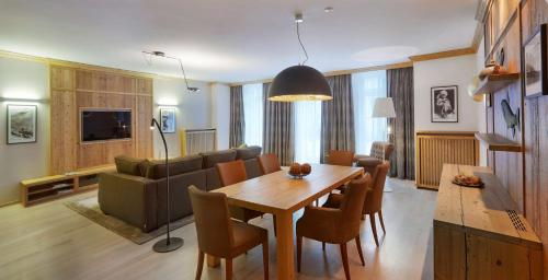 a living room with a dining table and a couch at Grand Hotel des Bains Kempinski in St. Moritz