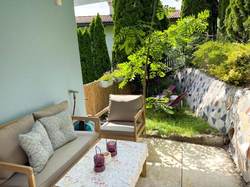 a patio with a couch and a chair and a table at Sunny Mountain Loft - Terrace & Garden in Thaur