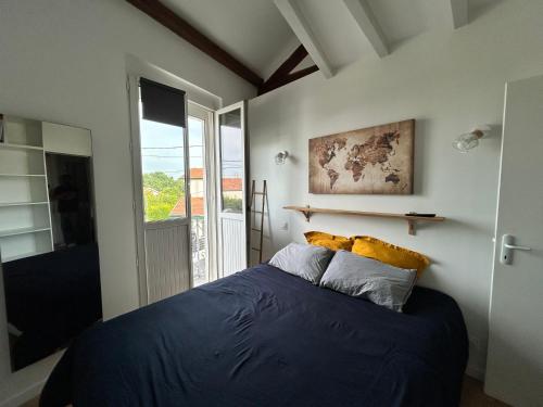 une chambre avec un lit bleu et une fenêtre dans l'établissement LA CHOUETTE DU LAC MARION, à Biarritz