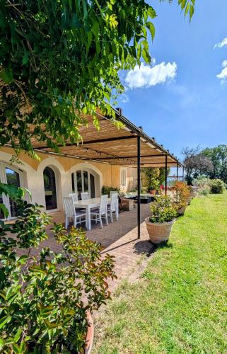 un patio avec une table et des chaises sous un pavillon dans l'établissement Appartement 5 personnes - Mas du Soleil, à Bagnols-sur-Cèze