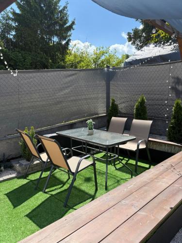 a patio with a table and chairs on the grass at PilisRelax-Stílusos Vendèghàz in Pilismarót
