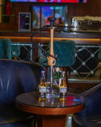 two bottles of beer sitting on a table at La Roche Hotel in Erbil