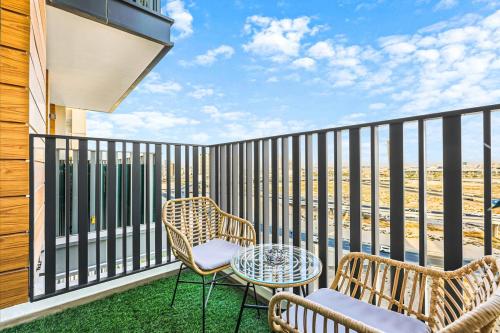 a balcony with two chairs and a table at Stylish Studio in JVC with Pool, Gym, Balcony & Modern Comforts in Dubai